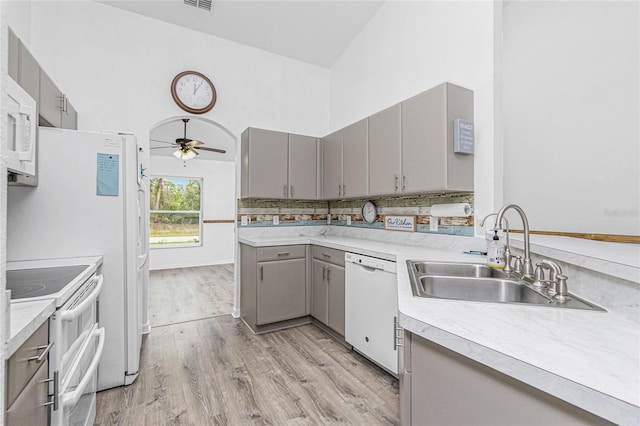 kitchen with white appliances, gray cabinetry, sink, light wood-type flooring, and ceiling fan