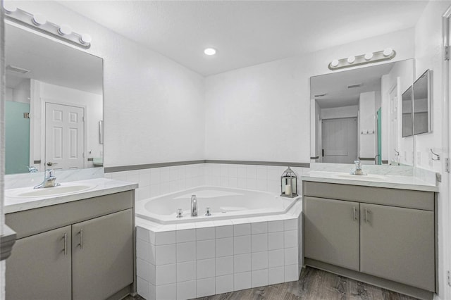 bathroom with vanity, hardwood / wood-style floors, and shower with separate bathtub