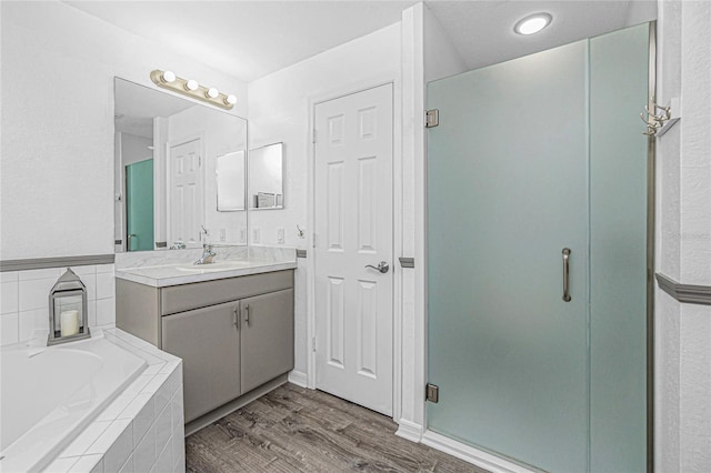 bathroom featuring vanity, plus walk in shower, and wood-type flooring