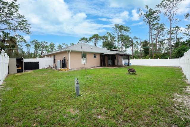 back of house with a gazebo and a yard