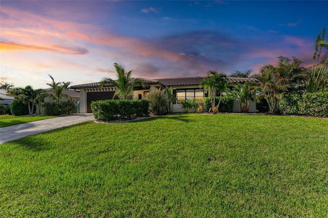 mediterranean / spanish-style house featuring a garage and a lawn