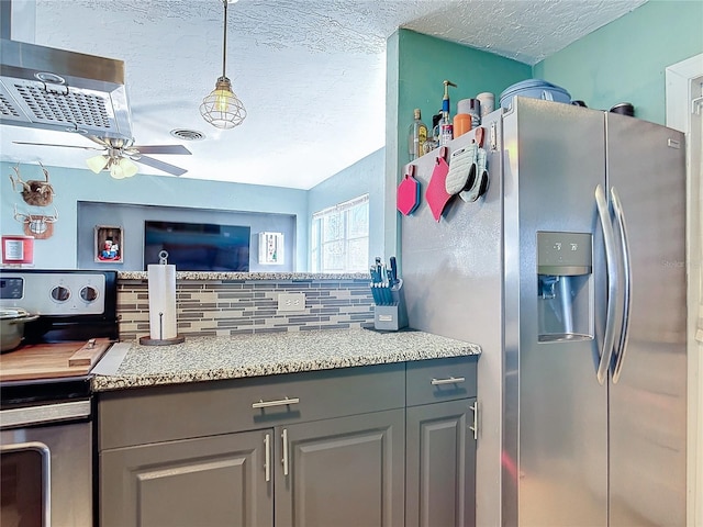 kitchen with appliances with stainless steel finishes, ceiling fan, decorative light fixtures, gray cabinets, and decorative backsplash