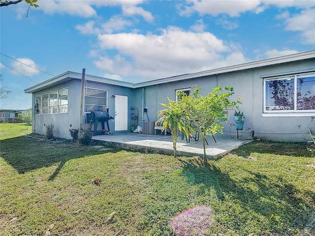 rear view of house featuring a patio area and a yard