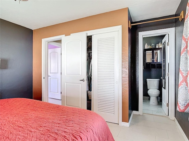 tiled bedroom featuring a closet and ensuite bathroom