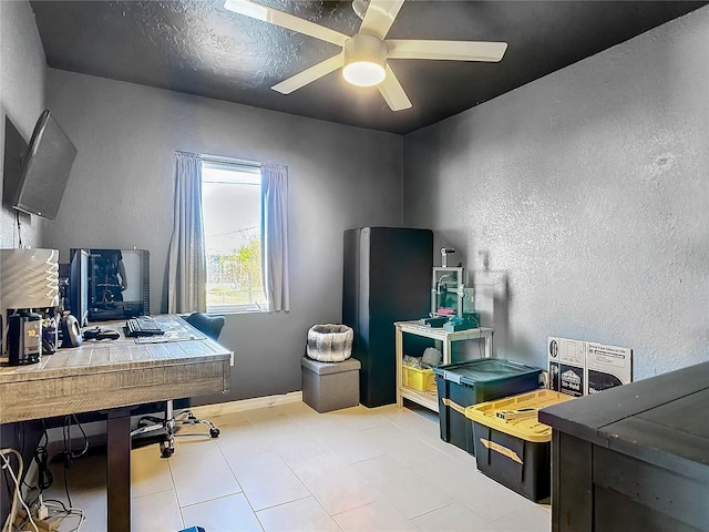 tiled home office featuring ceiling fan