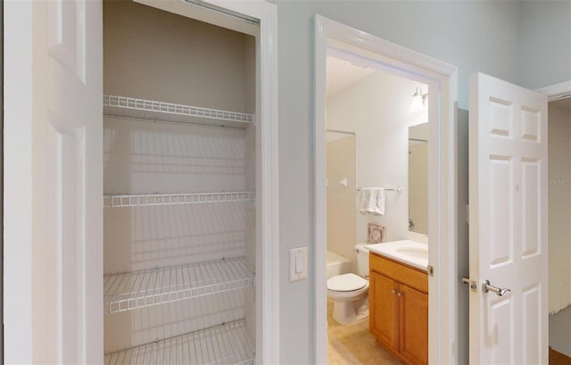 interior space with toilet, a bath, and vanity