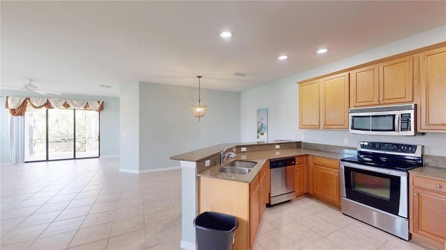 kitchen featuring appliances with stainless steel finishes, light tile patterned floors, hanging light fixtures, sink, and kitchen peninsula