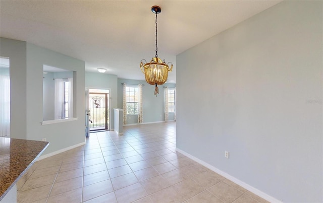 unfurnished dining area with light tile patterned floors and an inviting chandelier