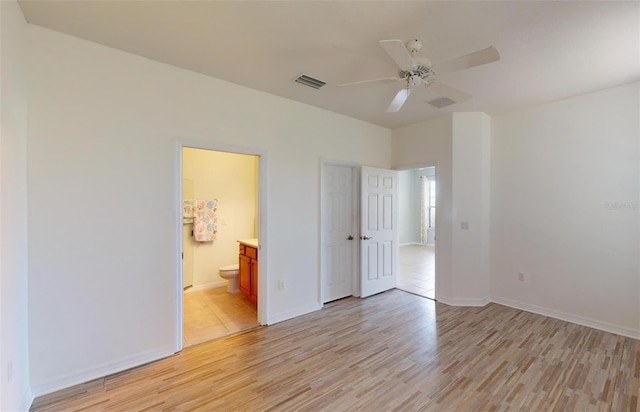 unfurnished bedroom with ceiling fan, connected bathroom, a closet, and light hardwood / wood-style flooring