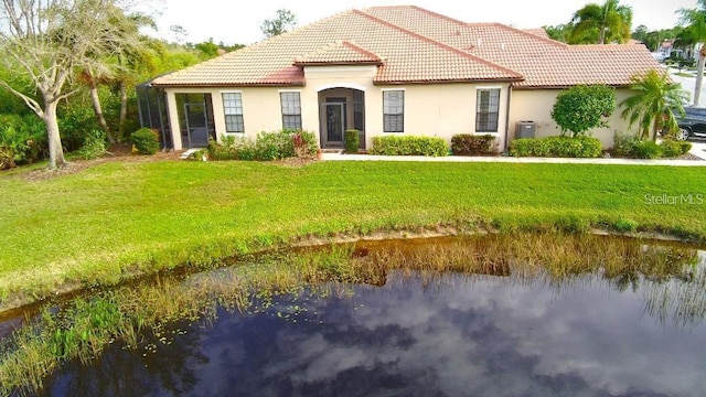 mediterranean / spanish-style house featuring a water view and a front lawn