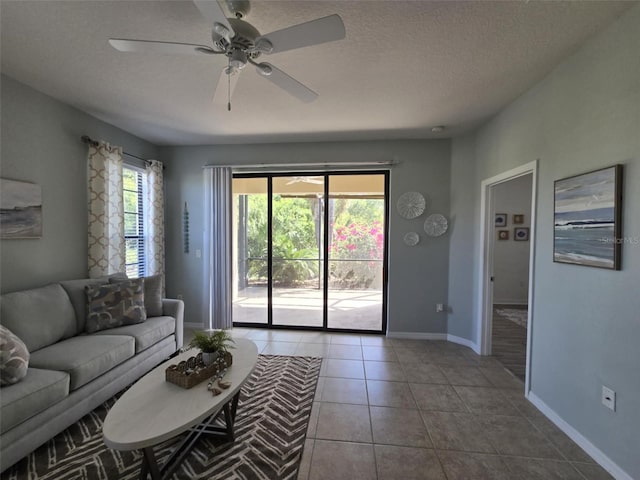 tiled living area featuring baseboards, a ceiling fan, and a textured ceiling