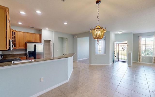 kitchen with a wealth of natural light, a chandelier, stainless steel appliances, and glass insert cabinets