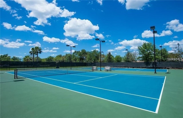 view of tennis court with fence and community basketball court