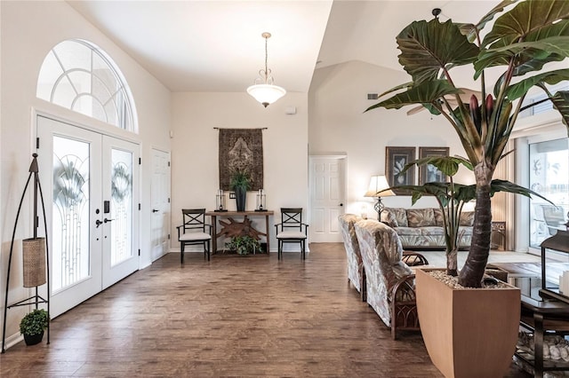 entrance foyer featuring dark wood-type flooring, vaulted ceiling, and french doors