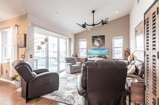 living room featuring hardwood / wood-style floors, lofted ceiling, and a chandelier