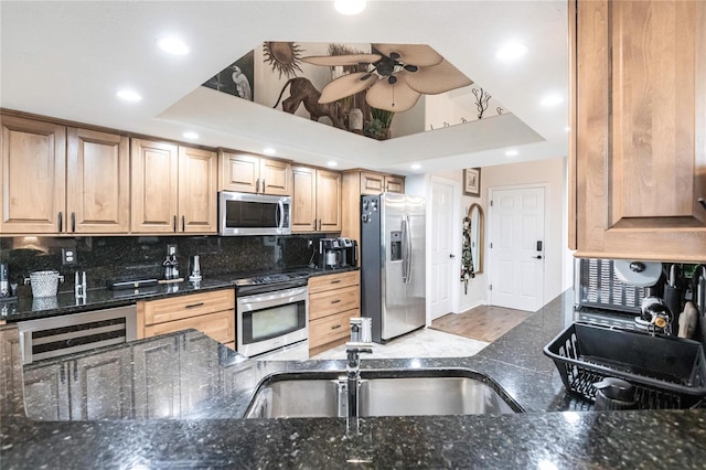 kitchen with stainless steel appliances, light wood-type flooring, decorative backsplash, dark stone countertops, and ceiling fan