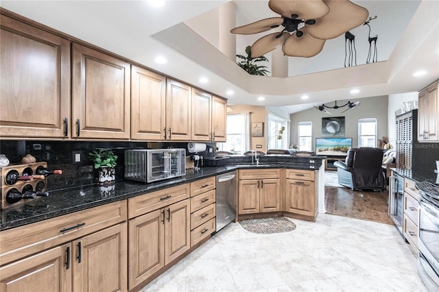 kitchen featuring stainless steel appliances, backsplash, dark stone countertops, kitchen peninsula, and ceiling fan