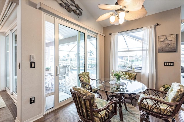 dining space with dark wood-type flooring, ceiling fan, and lofted ceiling