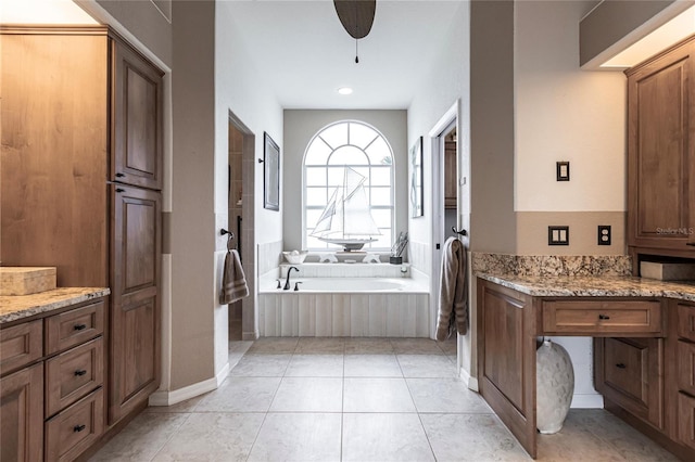 bathroom with vanity, tile patterned flooring, ceiling fan, and tiled tub