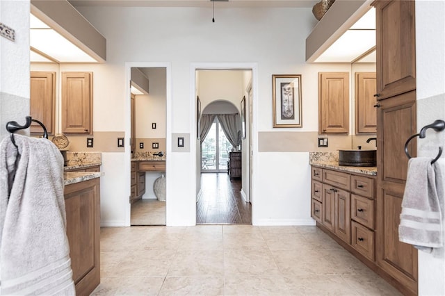 kitchen with light stone countertops, sink, and light wood-type flooring