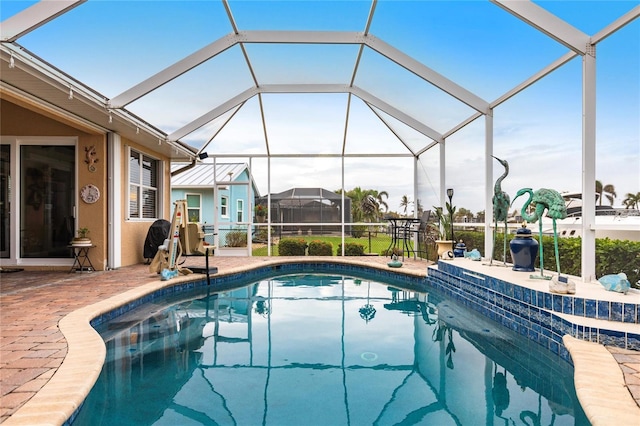 view of swimming pool featuring a patio and a lanai