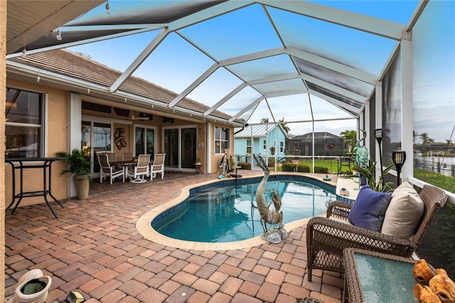 view of pool featuring ceiling fan, a patio, and a lanai