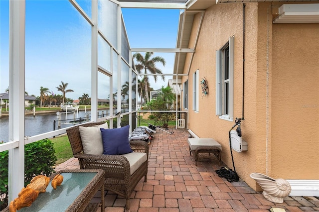 sunroom featuring a water view