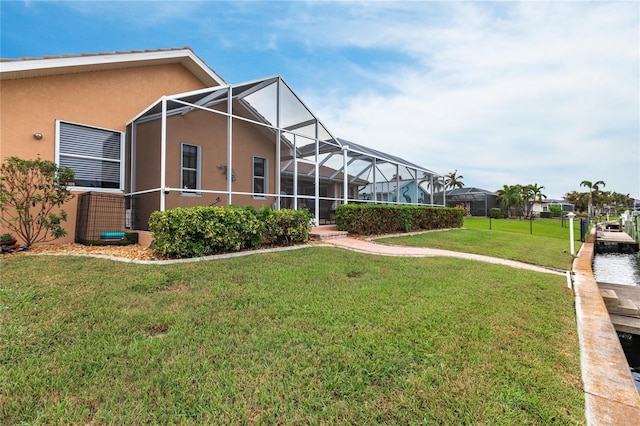 back of property with a lanai and a lawn