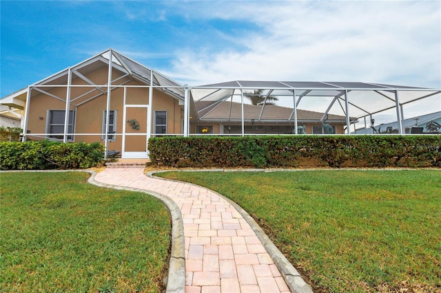 exterior space with glass enclosure and a yard