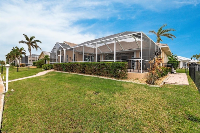 back of house with a yard and glass enclosure