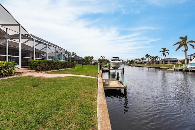 dock area with a water view, a lawn, and a lanai