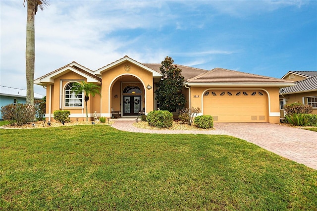 1215 Via Tripoli, Punta Gorda, FL 33950 - view of front of house featuring french doors, stucco siding, a garage, decorative driveway, and a front yard