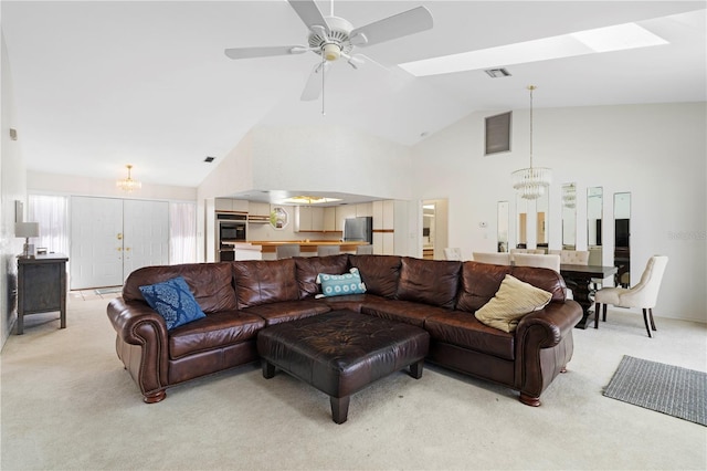 carpeted living room featuring high vaulted ceiling and ceiling fan with notable chandelier