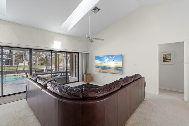 carpeted living room featuring a skylight, high vaulted ceiling, and ceiling fan