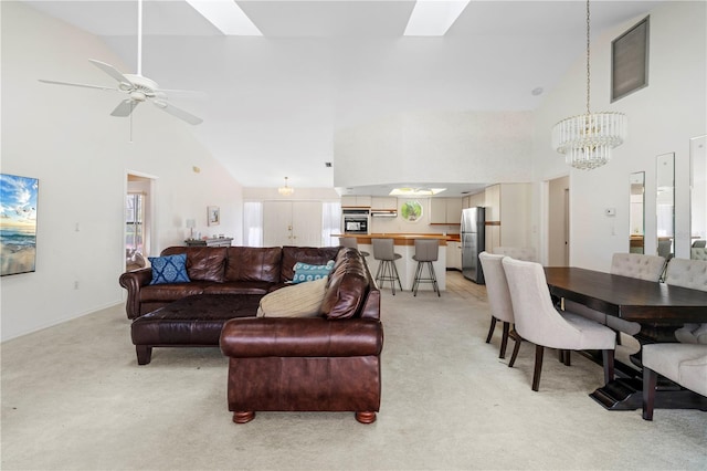 living room with light carpet, ceiling fan with notable chandelier, and high vaulted ceiling