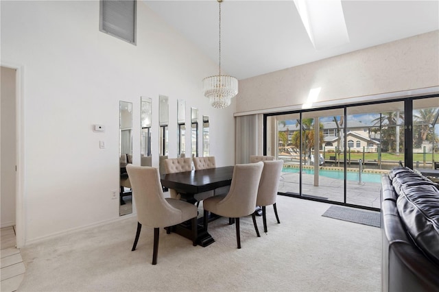 carpeted dining area featuring a notable chandelier and high vaulted ceiling