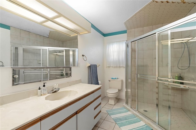 bathroom featuring vanity, toilet, a shower with shower door, and tile patterned flooring