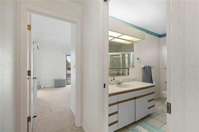 bathroom featuring vanity, a shower with shower door, toilet, and tile patterned flooring