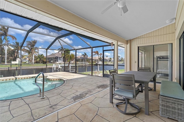 view of swimming pool featuring a patio, ceiling fan, a water view, and glass enclosure