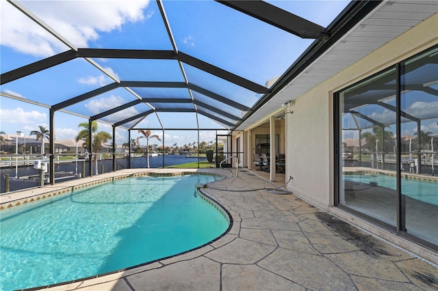 view of swimming pool featuring a patio area, a lanai, and a water view