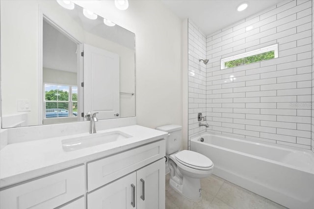 full bathroom featuring toilet, tiled shower / bath, vanity, and tile patterned flooring