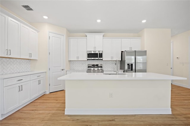 3390 Nadasky Ave, North Port, FL 34288 - kitchen with stainless steel appliances, a sink, a kitchen island with sink, tasteful backsplash, and white cabinetry