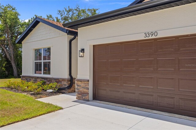 3390 Nadasky Ave, North Port, FL 34288 - view of front of house with stone siding, stucco siding, driveway, and an attached garage