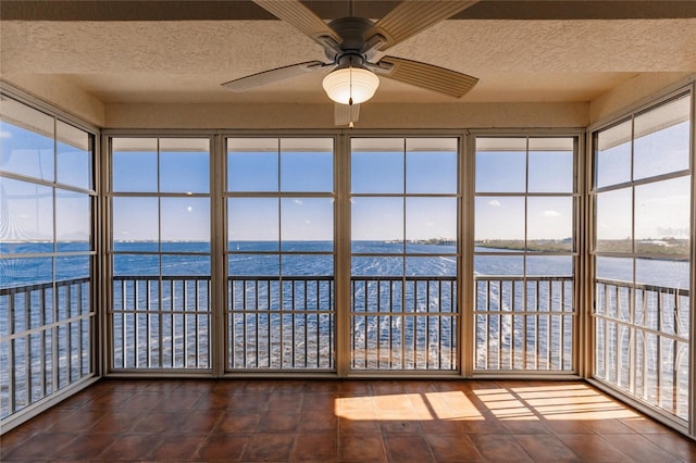 unfurnished sunroom featuring a water view and ceiling fan