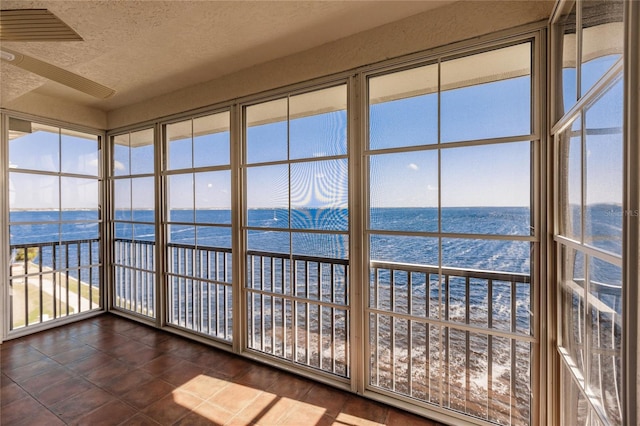 unfurnished sunroom featuring a water view