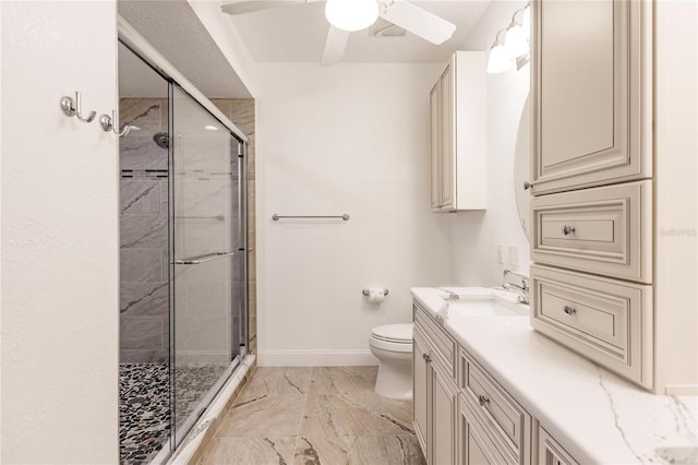 bathroom featuring toilet, vanity, a shower with door, and ceiling fan