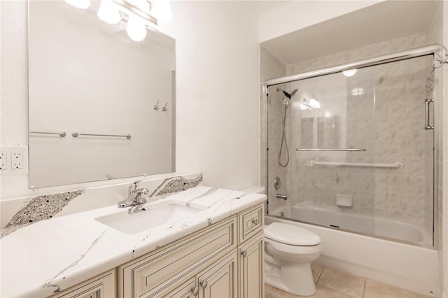 full bathroom featuring toilet, combined bath / shower with glass door, vanity, and tile patterned flooring