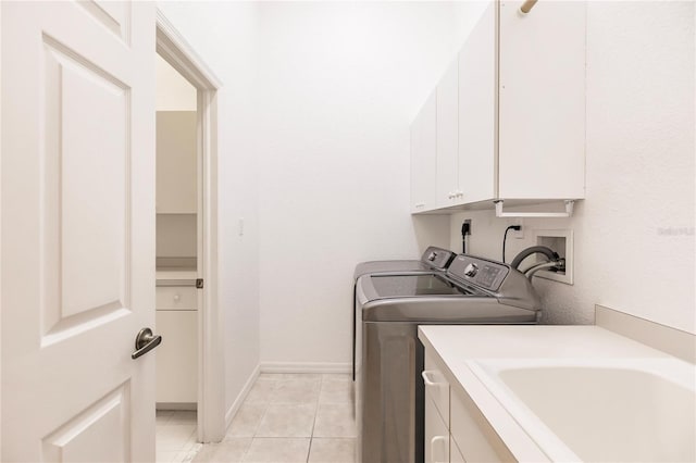 washroom with washer and clothes dryer, cabinets, and light tile patterned flooring