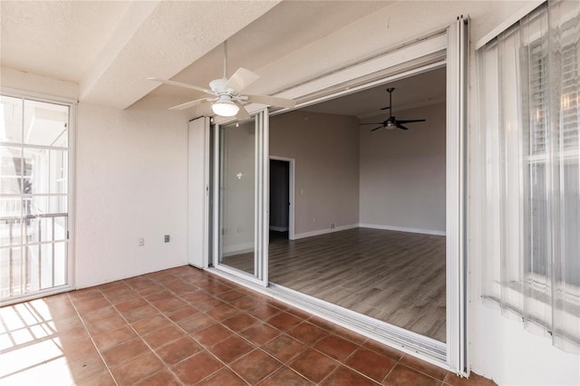 unfurnished sunroom featuring ceiling fan and vaulted ceiling