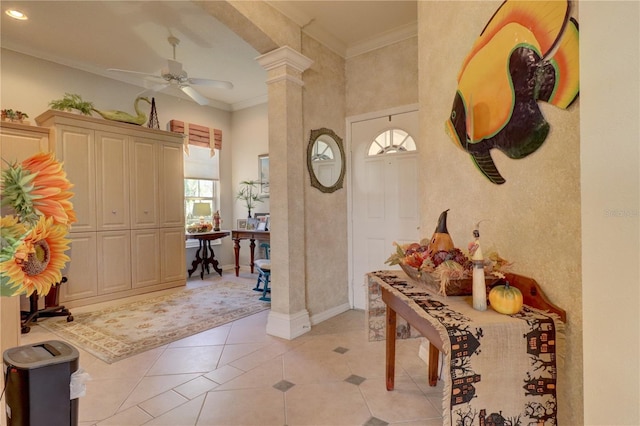 tiled foyer with crown molding, ceiling fan, and decorative columns